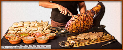 pernil presentado en mesa con panes y salsas